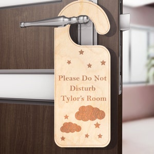 May include: A wooden door hanger with the text "Please Do Not Disturb Tyler's Room" and a cloud and star design.