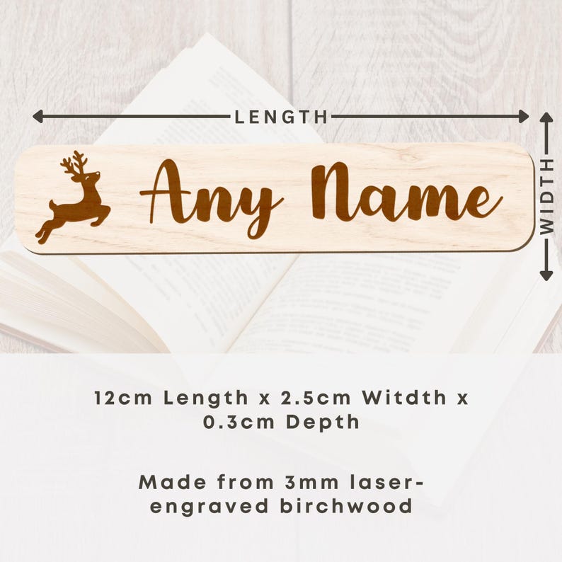 May include: A light-colored wooden nameplate with the text "Any Name" in a brown script font. A brown reindeer silhouette is on the left. The nameplate is 4.7 inches long, 1 inch wide, and 0.1 inches deep. Made from laser-engraved birchwood.