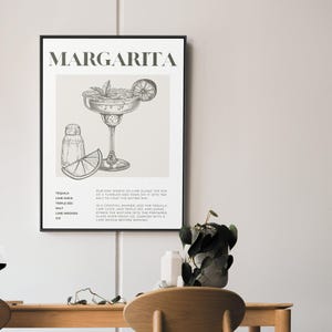 May include: A black and white printable poster with a drawing of a margarita cocktail and the ingredients and instructions for making the drink. The text reads "MARGARITA" and includes the ingredients: Tequila, Lime Juice, Triple Sec, Salt, Lime Wedges, Ice. The instructions read: "Rub one wedge of lime along the rim of a tumbler and then dip it into the salt to coat the entire rim. In a cocktail shaker, add the tequila, lime juice, and triple sec and shake. Strain the mixture into the prepared glass over fresh ice. Garnish with a lime wedge before serving."