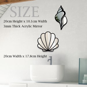May include: Two acrylic wall mirrors shaped like seashells. The larger mirror is a white seashell with a black outline. The smaller mirror is a brown seashell with a black outline. The text "SIZE" is written in black at the top of the image. The text "20cm Height x 10.1cm Width" and "3mm Thick Acrylic Mirror" is written in black below the mirrors. The text "20cm Width x 17.8cm Height" is written in black below the larger mirror.