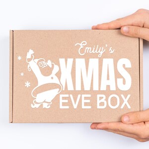 May include: A brown cardboard box with a white design featuring a cartoon Santa Claus, the text "Emily's Xmas Eve Box", and snowflakes.