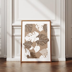 May include: A framed print with a brown background and a pattern of white and brown tropical leaves.