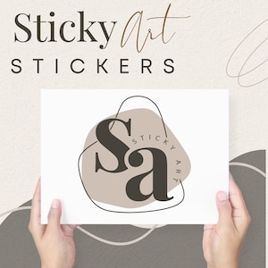 May include: A white card with a brown and black logo that says "Sa" with the words "Sticky Art" written around the logo. The card is being held by two hands.