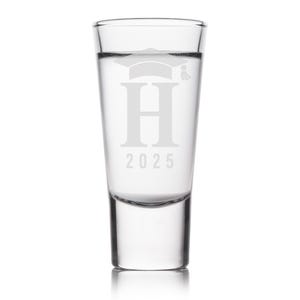 K&ouml;nnte beinhalten: Klares Schnapsglas mit einem Abschlusskappen-Design, dem Buchstaben "H" und der Jahreszahl "2025" auf der Vorderseite. Das Glas ist mit einer klaren Fl&uuml;ssigkeit gef&uuml;llt, vor wei&szlig;em Hintergrund.