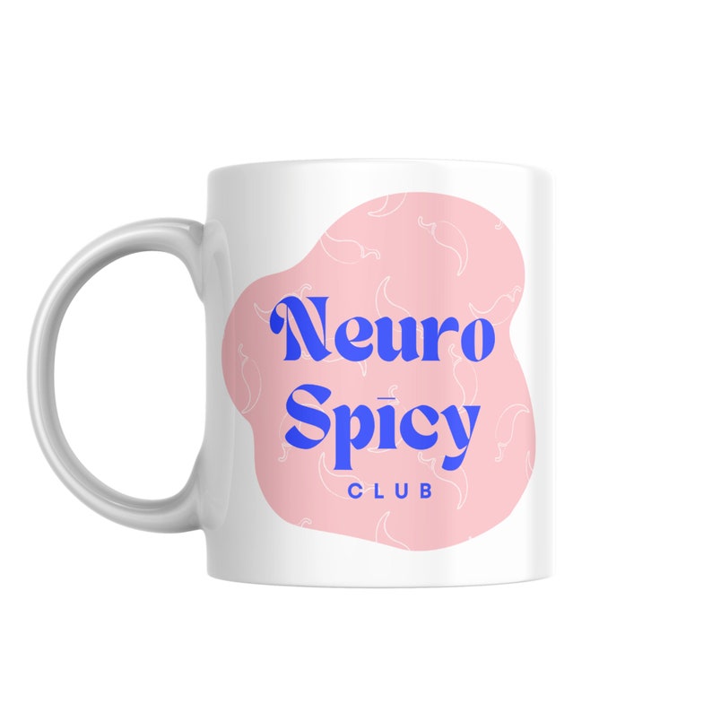 May include: White ceramic mug with a pink and white design. The design features a pink splotch with white chili pepper outlines and the text "Neuro Spicy Club" in blue.