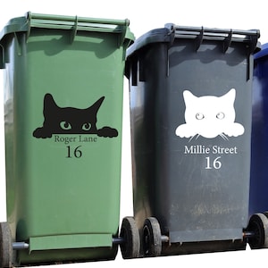 Puede incluir: Dos contenedores de basura con ruedas, uno verde y otro gris, con calcoman&iacute;as de gato. El contenedor verde tiene una calcoman&iacute;a de gato negro con el texto "Roger Lane 16". El contenedor gris tiene una calcoman&iacute;a de gato blanco con el texto "Millie Street 16".