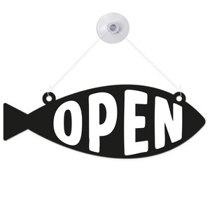 May include: Black fish-shaped sign with the word "OPEN" in white. The sign is suspended by a clear suction cup and string. The sign is designed to be hung on a window or door to indicate a business is open.