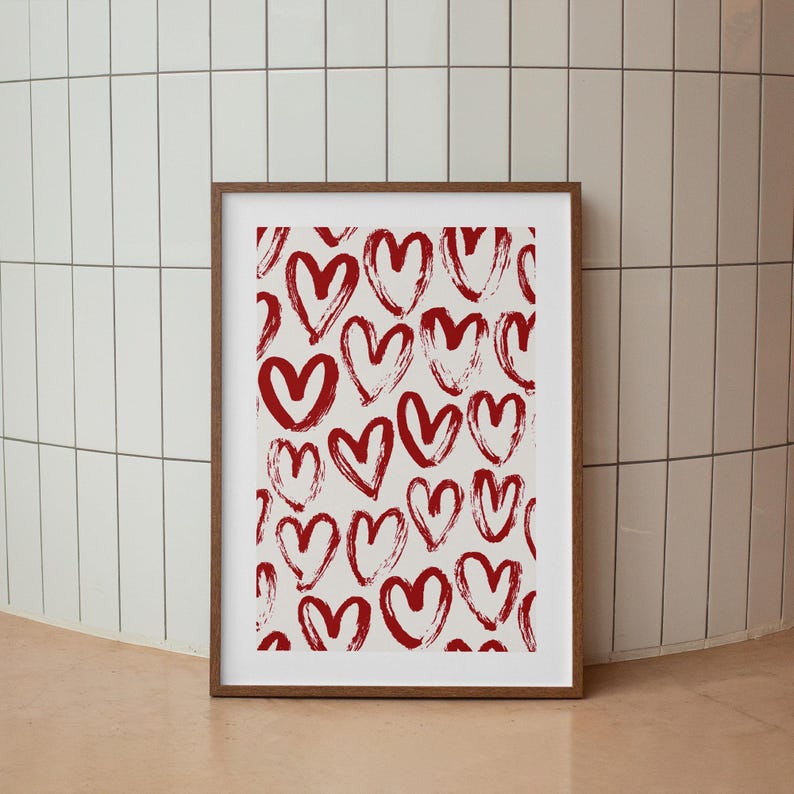 May include: A framed print with a white background and a pattern of red hand-drawn hearts.