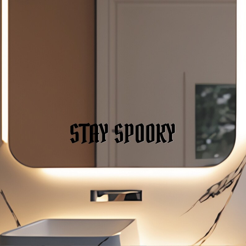 May include: A bathroom mirror with a black vinyl decal that reads "STAY SPOOKY".