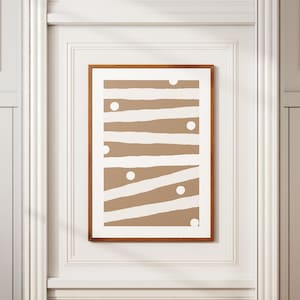 Op de afbeelding: Een ingelijst print met een bruin en wit abstract ontwerp. Het ontwerp heeft witte strepen en cirkels op een bruine achtergrond.