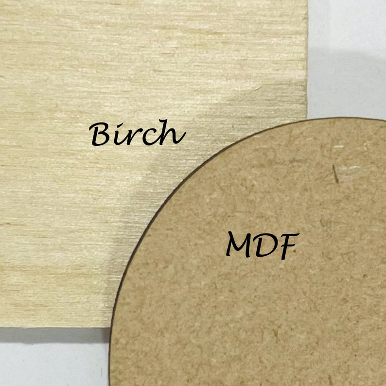 May include: Close-up of two wood samples. One is a light-colored rectangular piece of birch wood. The other is a rounded, brown MDF (medium-density fiberboard) piece. The word "Birch" is written on the birch wood, and the letters "MDF" are written on the MDF piece.