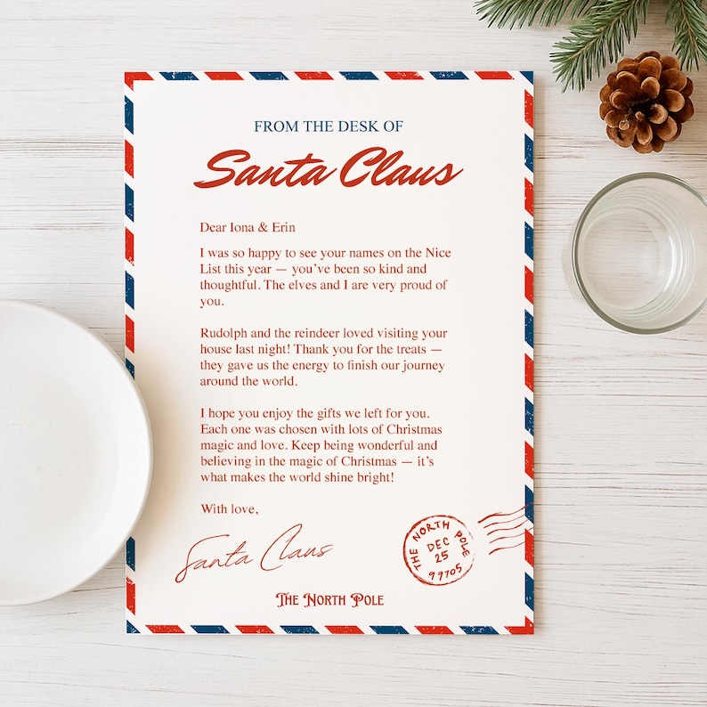 May include: A letter from Santa Claus with a red, white, and blue border. The letter is addressed to Iona & Erin and includes a message about the Nice List, Rudolph, and Christmas gifts. A pine cone and glass are in the background.