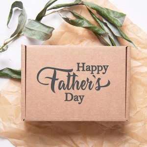 Puede incluir: Una caja de cart&oacute;n marr&oacute;n con el texto "Happy Father's Day" impreso en ella.