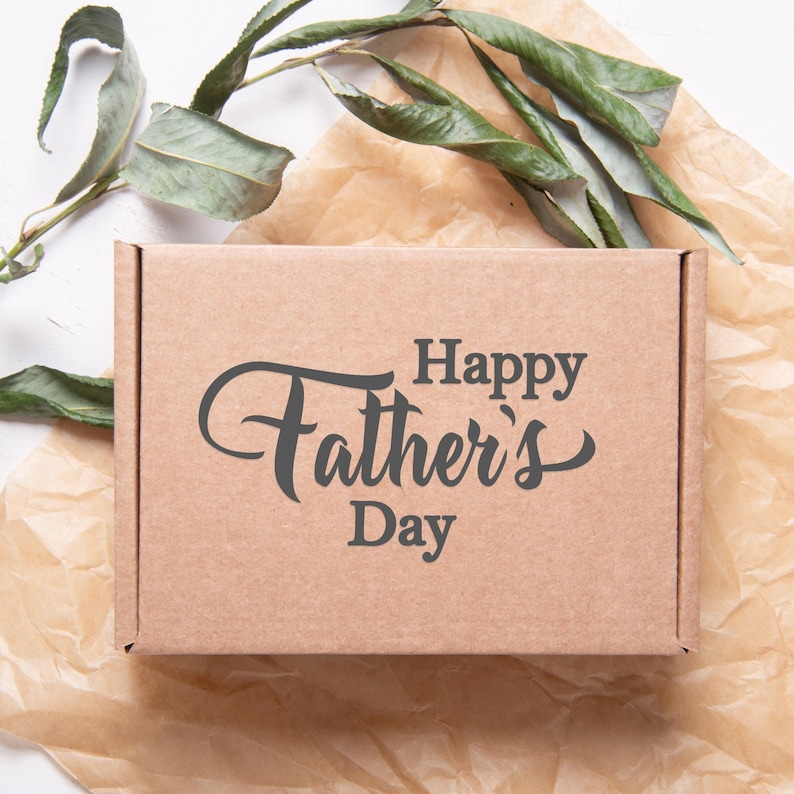 Puede incluir: Una caja de cart&oacute;n marr&oacute;n con el texto "Happy Father's Day" impreso en ella.