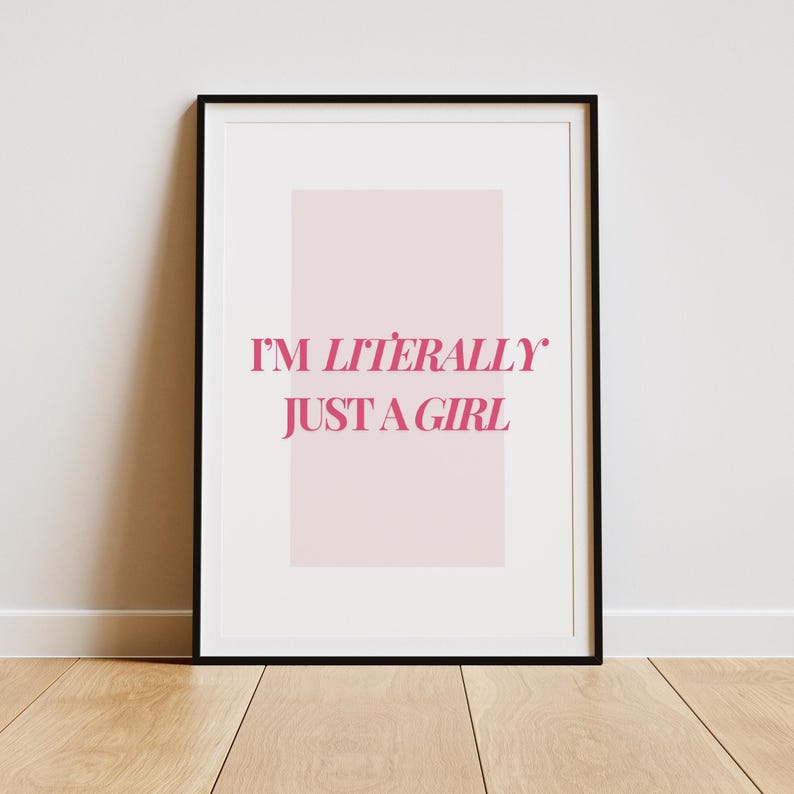 May include: A black framed print with a pink background and the text "I'M LITERALLY JUST A GIRL" in pink.
