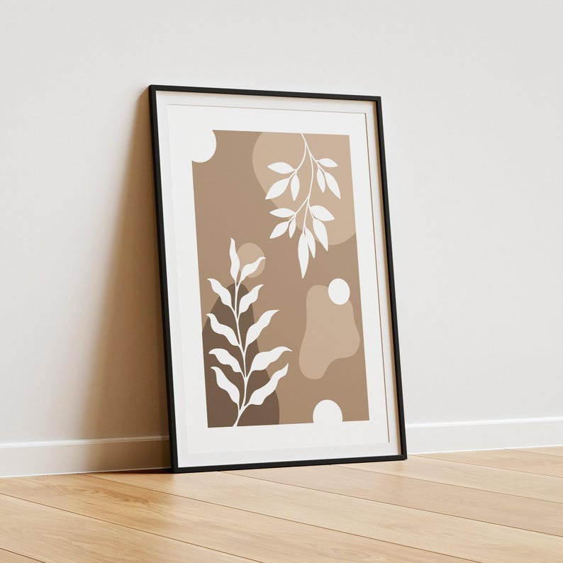 May include: A framed print with a minimalist design featuring white stylized leaves on a brown background with abstract shapes.