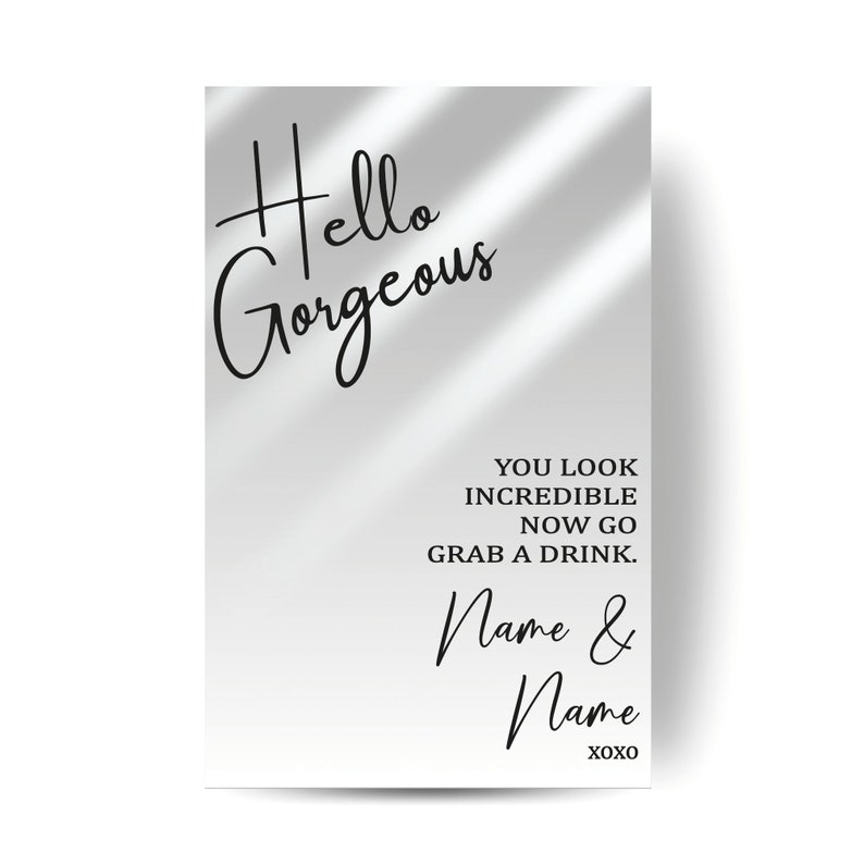 May include: A white rectangular sign with the words "Hello Gorgeous" in elegant black script. Below, it reads "YOU LOOK INCREDIBLE NOW GO GRAB A DRINK. Name & Name XOXO" in a similar font. The background is a gradient of gray.