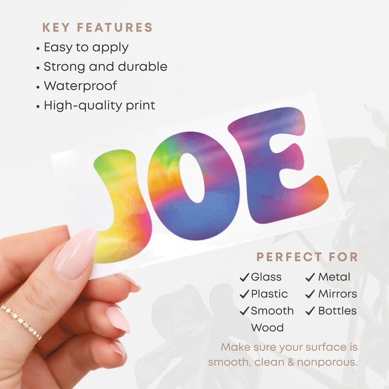 May include: A white sticker with the name "JOE" in large, colorful, tie-dye style letters. The sticker is held by a hand with a gold ring. The text "KEY FEATURES" and "PERFECT FOR" are also visible.