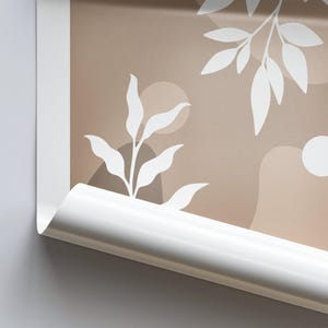 May include: A close-up of a brown and white abstract print with a white leaf design. The print is rolled up and the edge of the roll is visible.