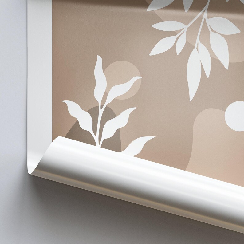 May include: A close-up of a brown and white abstract print with a white leaf design. The print is rolled up and the edge of the roll is visible.