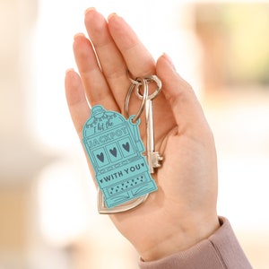 May include: A blue and white keychain shaped like a slot machine with the text "I hit the JACKPOT WITH YOU".