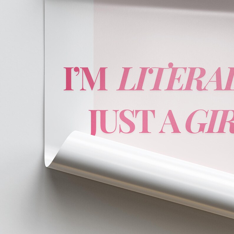 May include: A white poster with pink text that reads "I'm literally just a girl". The poster is partially rolled up at the bottom.