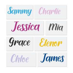 May include: Rectangular white labels with names in various colors. Names include "Sammy" in blue, "Charlie" in pink, "Jessica" in magenta, "Mia" in gray, "Grace" in black, "Elenor" in yellow, "Chloe" in lavender, and "James" in navy.