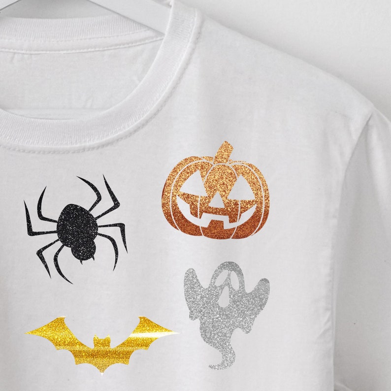 May include: White t-shirt with a gold glitter bat, a silver glitter ghost, a black glitter spider, and an orange glitter pumpkin.