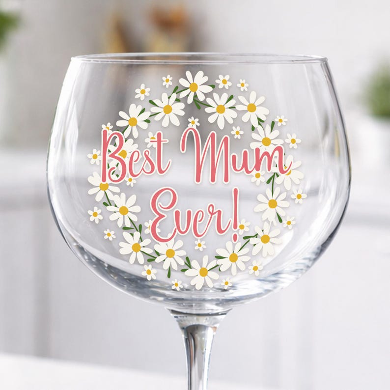 Personalised Best Mum Ever wine glass with daisy wreath design, floral Mother's Day gift, feminine pink typography on clear stemmed glass.