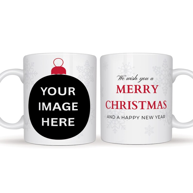 May include: White ceramic mug with a Christmas theme. One side features a black ornament design with the text "YOUR IMAGE HERE". The other side has the text "We wish you a MERRY CHRISTMAS AND A HAPPY NEW YEAR" in red.