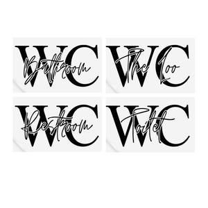 May include: Four white square signs with black lettering. Each sign has the letters WC in large black font with a smaller word underneath. The words are "Bathroom", "The Loo", "Restroom", and "Toilet".