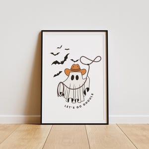 May include: A white ghost wearing a brown cowboy hat and holding a lasso. The ghost is surrounded by bats and the text "Let's go ghouls".