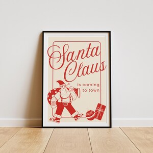 Puede incluir: Un p&oacute;ster de estilo vintage con una ilustraci&oacute;n roja de Santa Claus llevando una bolsa de regalos y tocando una bocina. El texto dice "Santa Claus is coming to town".