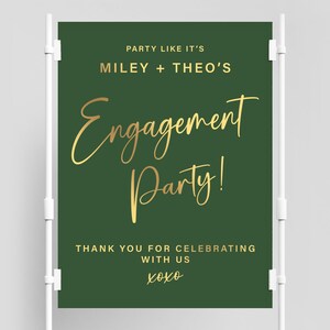 以下が含まれることがあります： 緑色の婚約パーティーの看板で、金色の文字で「Party Like It's Miley + Theo's Engagement Party! Thank You For Celebrating With Us xoxo」と書かれています。