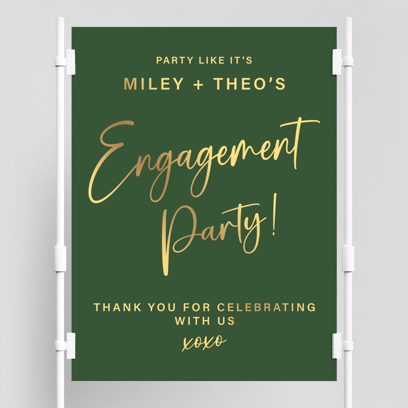 以下が含まれることがあります： 緑色の婚約パーティーの看板で、金色の文字で「Party Like It's Miley + Theo's Engagement Party! Thank You For Celebrating With Us xoxo」と書かれています。