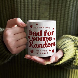 Puede incluir: Taza de cer&aacute;mica blanca con texto rojo que dice "You are not bad for some random off the internet". El texto est&aacute; rodeado de peque&ntilde;os corazones rojos.