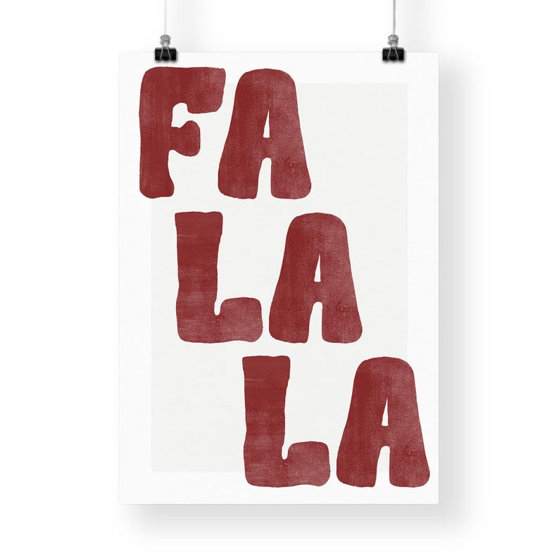 May include: A white poster with the words "FA LA LA" in a bold, red, textured font. The text is stacked vertically, with "FA" at the top, followed by "LA" twice. The poster is hung with black clips.