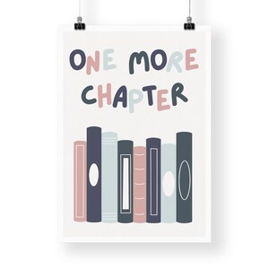 May include: A white poster with the text "ONE MORE CHAPTER" in colorful, rounded letters. Below the text is a row of seven colorful books.