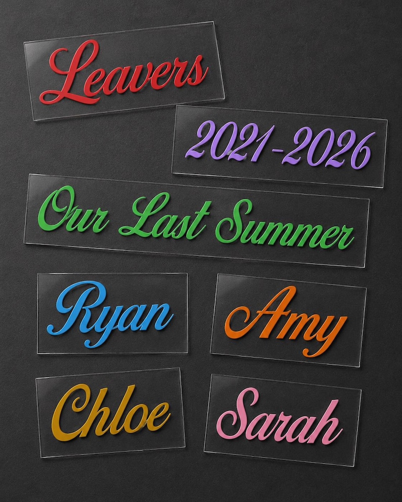 May include: A collection of clear acrylic nameplates with colorful text. The nameplates feature the words "Leavers," "Our Last Summer," and the years "2021-2026." Individual nameplates display the names "Ryan," "Amy," "Chloe," and "Sarah."