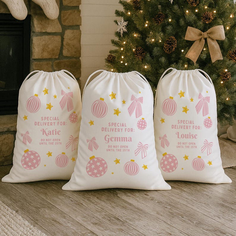 Puede incluir: Tres bolsas de regalo navide&ntilde;as blancas con cierres de cord&oacute;n. Cada bolsa presenta dise&ntilde;os festivos rosas y amarillos, incluyendo adornos, lazos y estrellas. El texto en las bolsas dice "Special Delivery For:" seguido de un nombre y "Do Not Open Until the 25th."