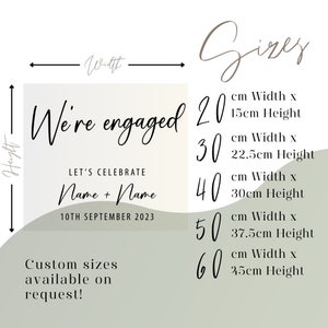 May include: A light green and white printable sign with the text "We're engaged" and "Let's Celebrate" with the option to add names and a date. The sign also includes a size chart with different width and height options in centimeters.