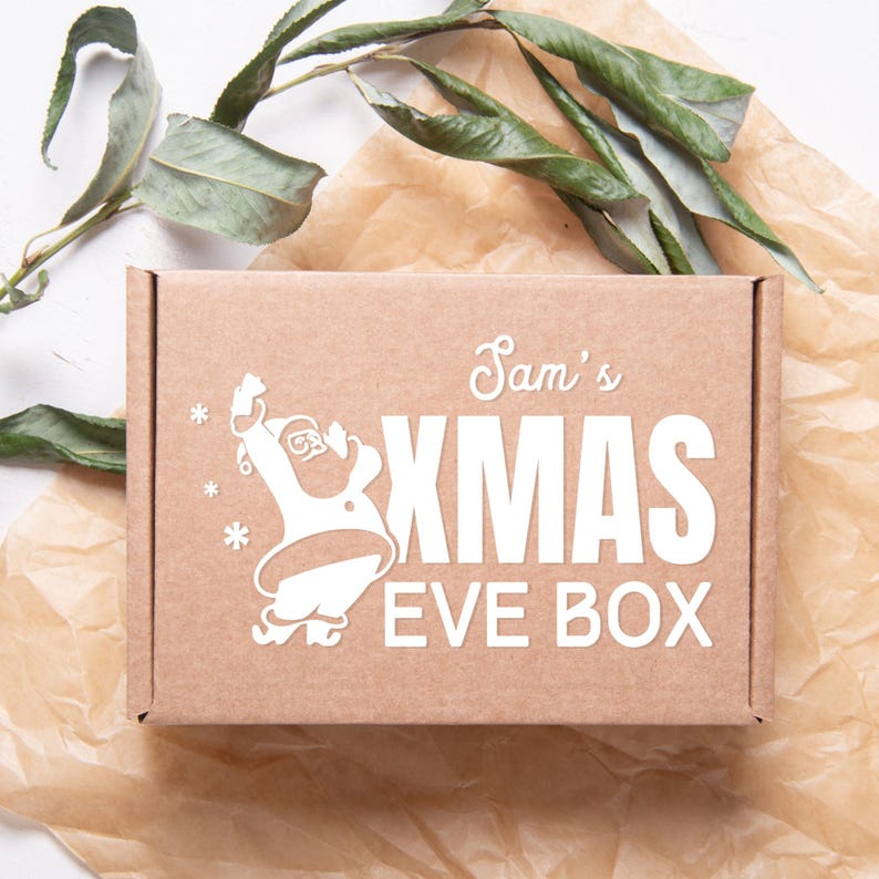 May include: A brown cardboard box with a white design featuring a cartoon Santa Claus, the text "Sam's Xmas Eve Box", and snowflakes.