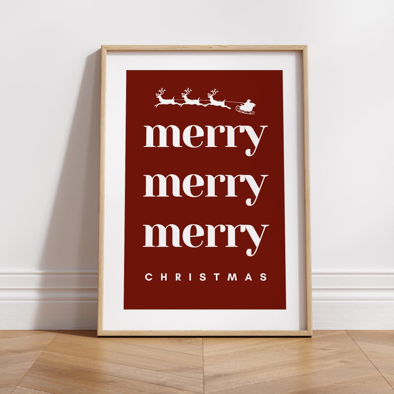 May include: A framed Christmas print with a red background and white text. The words "merry merry merry" are stacked vertically, with "CHRISTMAS" at the bottom. A white illustration of Santa's sleigh and reindeer is at the top.