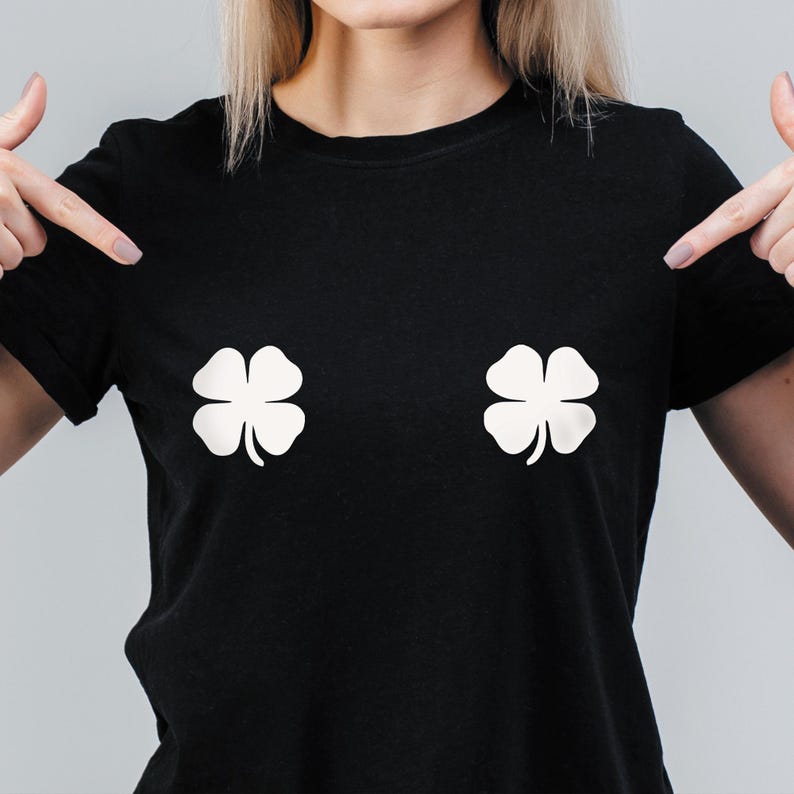 May include: Black t-shirt with two white four-leaf clover designs. The clovers are positioned on the chest area of the shirt. The shirt is a crew neck style.