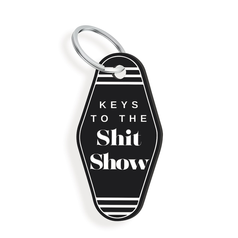 May include: Black motel key chain with white text that reads "Keys to the Shit Show".
