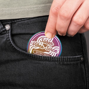 May include: A rainbow iridescent metal pin with the text "Sober Vibes Since: 01/01/2024" in a retro font.