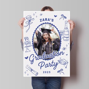 May include: A white poster with blue illustrations for a graduation party. The poster includes a photo of a graduate, the text "Zara's Graduation Party 2025", and drawings of a cake, champagne, and a scroll.