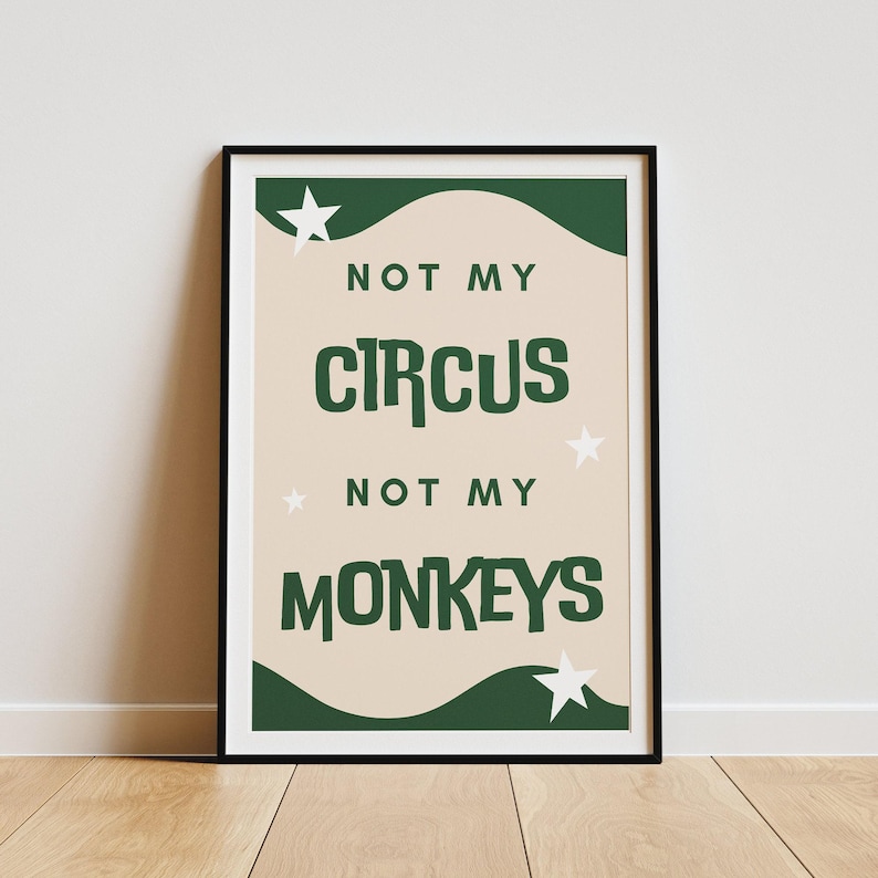 May include: A green and white print with the text "Not my circus, not my monkeys" on a beige background. The print is framed in a black frame.