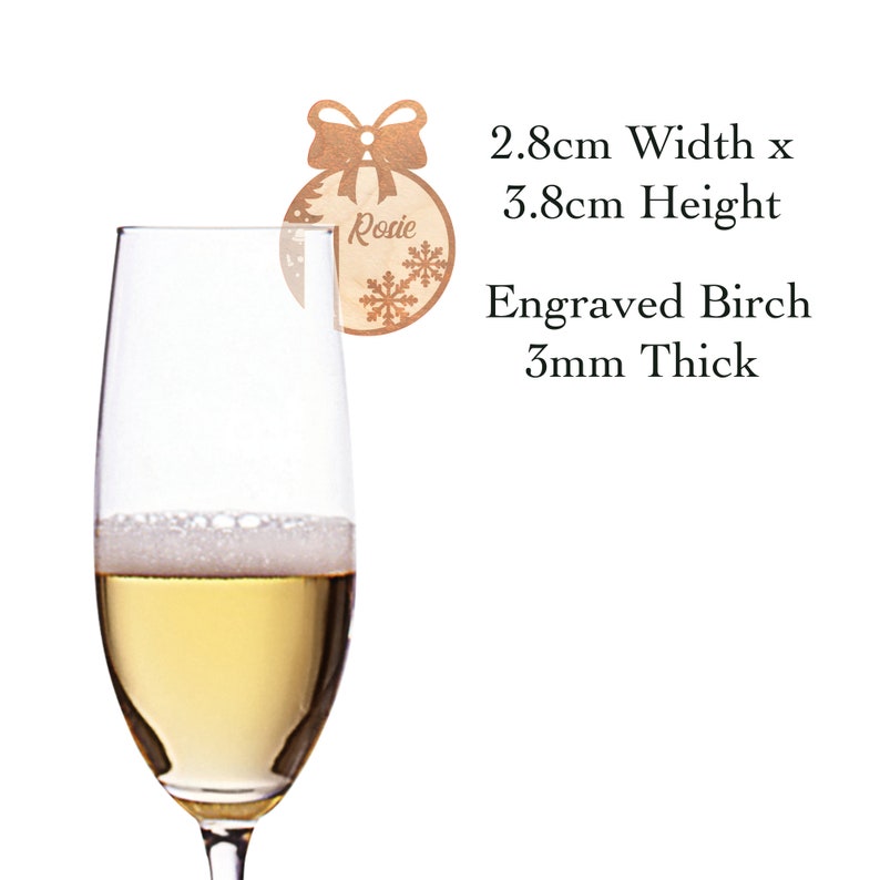 May include: A wooden Christmas ornament with a bow and snowflake design. The ornament is engraved with the name "Rosie" and measures 2.8 inches wide by 3.8 inches tall. It is made of 3mm thick birch wood.