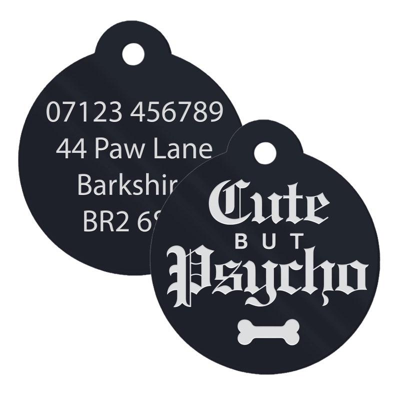May include: Black round dog tag with white text. The tag has a phone number, address, and the text "Cute But Psycho" with a bone symbol.